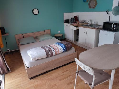 1 dormitorio con 1 cama con mesa y cocina en Studio Madeleine "endroit calme" en Morlaix