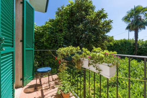 a balcony with potted plants and a green fence at Au Jardin fleuri in San Giovanni Lupatoto