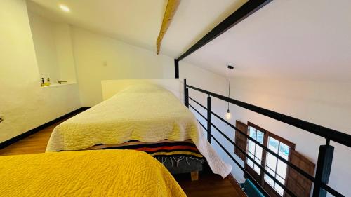 ボゴタにあるCasa Villalbaの小さな部屋のベッド2台 黄色い毛布付