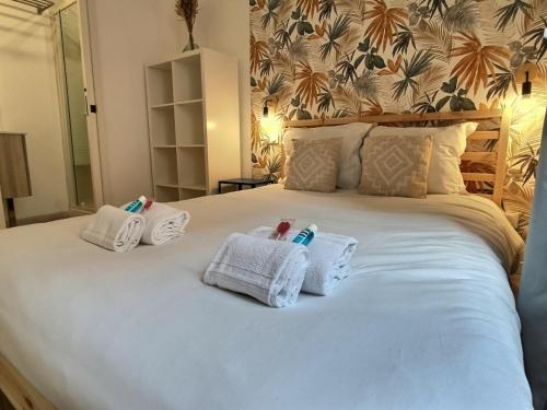 Deux bébés sont assis sur un lit avec des serviettes dans l'établissement La Palmeraie - Hyper Centre - Fibre, à Albi