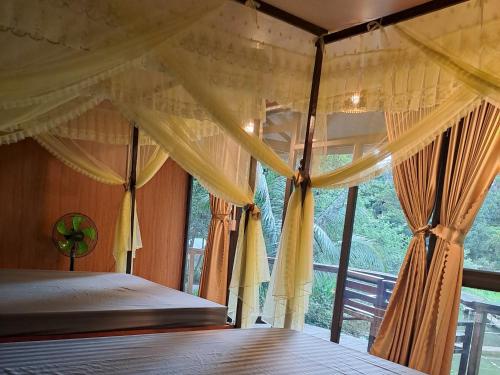 une chambre avec un lit et une grande fenêtre dans l'établissement Thung Sen Tam Coc Chalets, à Ninh Binh