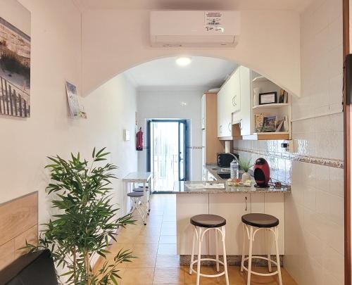 een keuken met twee krukken in het midden van een kamer bij Casa África y Ramona in Redondela