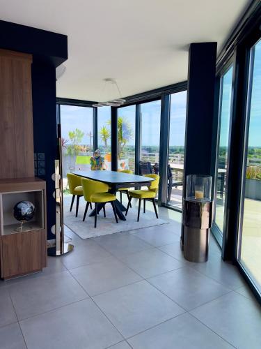 une salle à manger avec une table et des chaises jaunes dans l'établissement Luxueux et unique Penthouse en Rooftop à Montpellier, à Montpellier