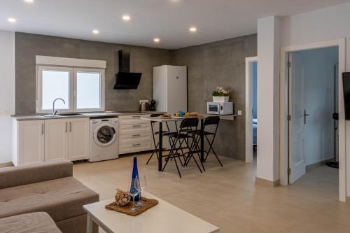 a kitchen and living room with a couch and a table at Kiposhi Beach Apartments Punta Mujeres in Haría