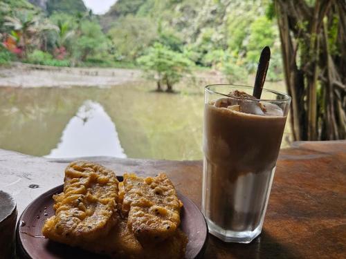 a plate with two pastries and a drink on a table at Thung Sen Tam Coc Chalets in Ninh Binh