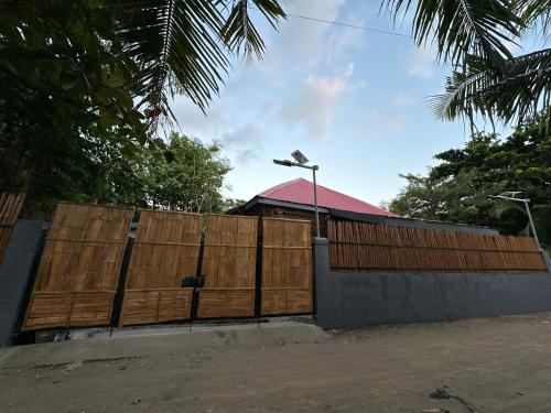 a fence with a wooden gate with a street light at Amakan Beachfront Private House Bataan in Bagac