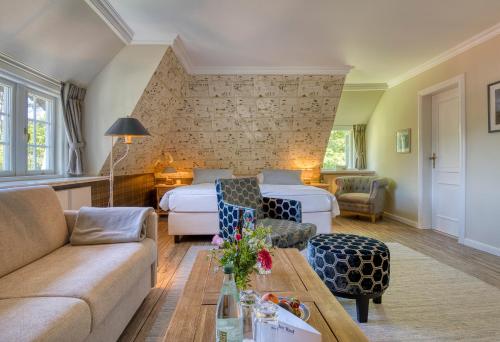 a hotel room with two beds and a couch at Boutiquehotel Seiler Hof Keitum in Keitum
