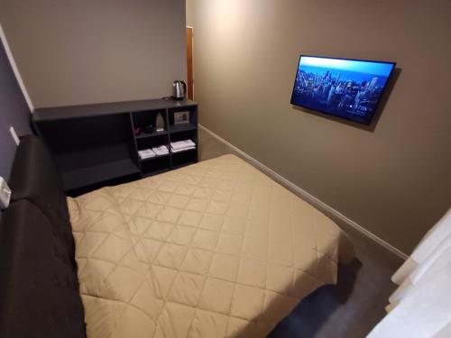 1 dormitorio con 1 cama y TV en la pared en Anchorena 1117 Hotel Suite And Hostel en Buenos Aires