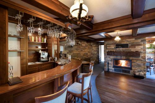 a bar in a room with a fireplace at Vila GRAND in Smokovce