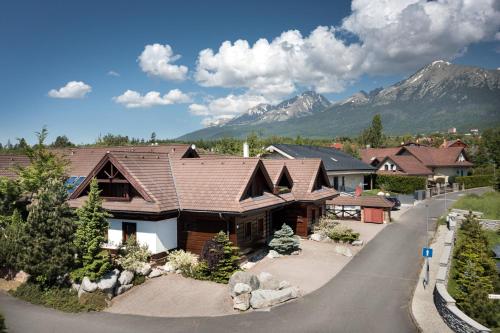 a large house with mountains in the background at Vila GRAND in Smokovce