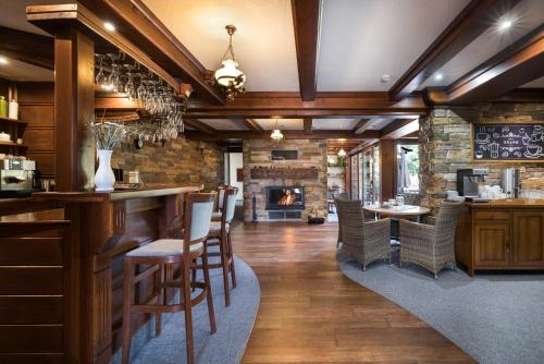 a bar in a restaurant with a fireplace at Vila GRAND in Smokovce