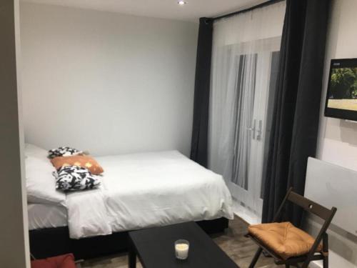 a small bedroom with a bed and a table at Cosy 1-Bed Studio in Northolt perfect to unwind in Northolt