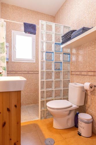 a bathroom with a toilet and a sink and a window at Parisito beach -Villa con piscina privada cerca de la playa in Chiclana de la Frontera