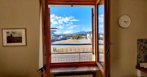 a window with a view of a street and a clock at Residenza Aleardo in Domegliara