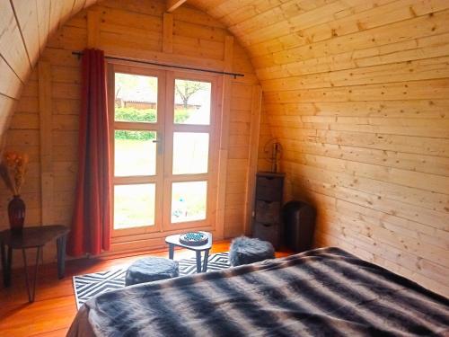 1 dormitorio con cama y ventana en CAMPING VERT LAVANDE en Belmont-sur-Rance