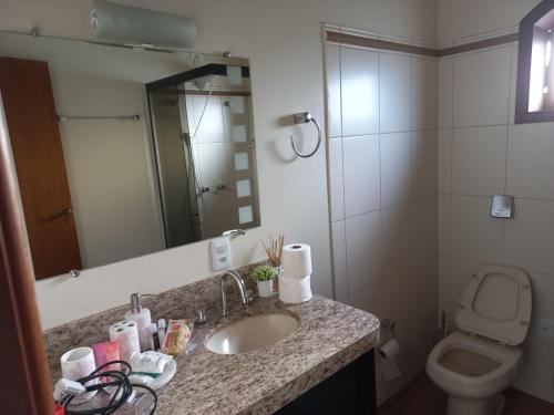 a bathroom with a sink and a toilet at Hospedagem Aconchegante in Espirito Santo Do Pinhal
