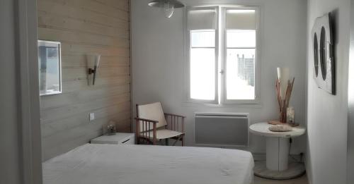 een slaapkamer met een bed, een tafel en een raam bij Maison de 2 chambres avec jardin clos a Saint Clement des Baleines in Saint-Clément-des-Baleines