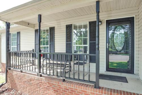 a porch with a black railing and a door at Above-Ground Pool and Backyard at Murfreesboro Home! in Murfreesboro