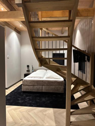 sypialnia z łóżkiem na podwyższeniu i drewnianymi schodami w obiekcie Hotel Restaurant Het Witte Paard w mieście Delden