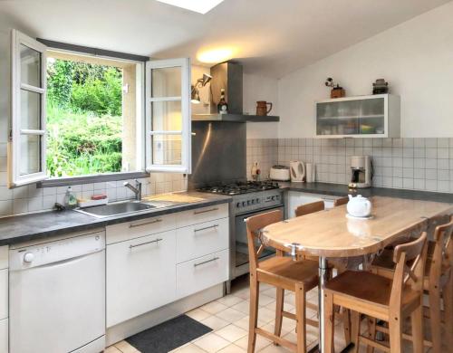 cocina con mesa de madera y fregadero en Maison de 6 chambres avec jardin clos et wifi a Pordic, en Pordic
