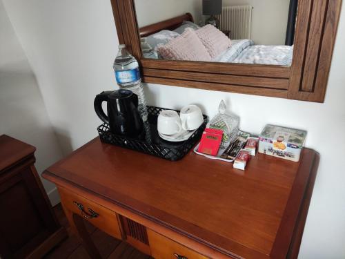 eine hölzerne Kommode mit einem Spiegel darüber in der Unterkunft Marianne Cottage Chambre d'Hotes in Couvains