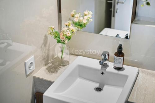 a bathroom with a sink and a vase of flowers at Sarwa by Kozystay - Paskal in Bandung