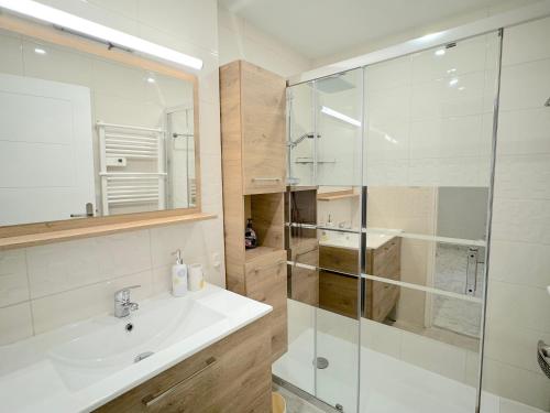 une salle de bain avec un lavabo et une douche en verre dans l'établissement Beau 3P à 4 min des plages centre Juan Les Pins, à Antibes
