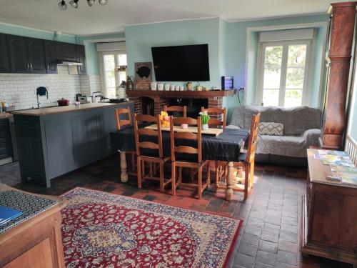 eine Küche und ein Wohnzimmer mit einem Tisch und einer Couch in der Unterkunft Marianne Cottage Chambre d'Hotes in Couvains