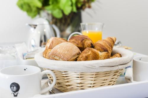 Espace Zen'ing في Gondecourt: سلة من الخبز على طاولة مع كوب من عصير البرتقال
