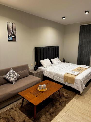 uma sala de estar com uma cama e um sofá em Deluxe Cabana with Vagaza signature in Hacienda Bay North Coast em El Alamein