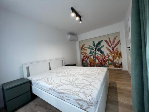 a bedroom with a bed and a painting on the wall at Best Apartman Boglár in Balatonboglár
