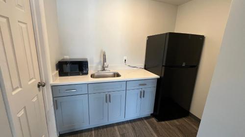 a kitchen with a sink and a black refrigerator at Motel 6 East Windsor, NJ Hightstown in East Windsor
