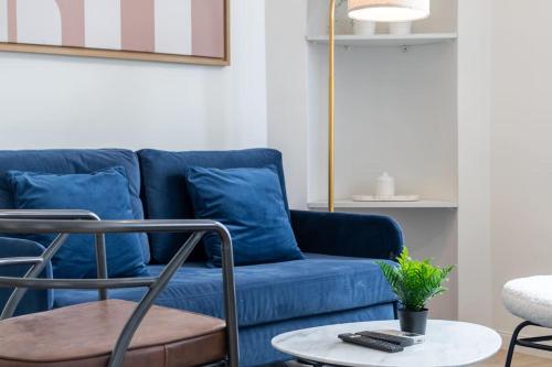 un sofá azul con almohadas azules en la sala de estar. en B3#Two Bedrooms#Champs Elysées#Arc de Triomphe#AC, en París