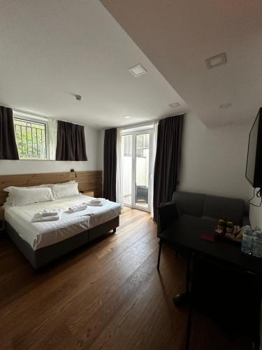 a bedroom with a bed and a couch and windows at GRANDI 32 Boutique Residence in Segrate