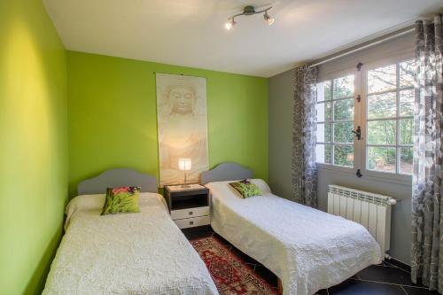 deux lits dans une chambre aux murs verts dans l'établissement Les Roitelets, à Mimizan-Plage