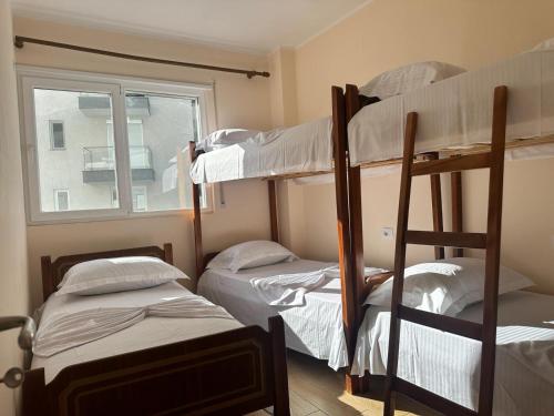 a room with three bunk beds and a window at Apartment Rrihnaj in Shëngjin