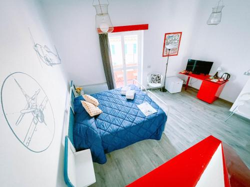 - une chambre avec un lit bleu et un dessin au mur dans l'établissement Ostello Bello Genova, à Gênes