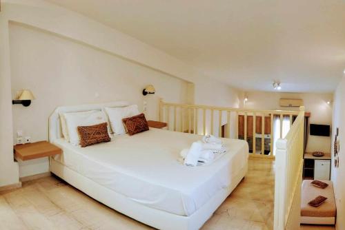 ein Schlafzimmer mit einem großen weißen Bett in einem Zimmer in der Unterkunft Lofos Apartments in Prínos