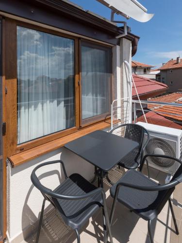 a black table and chairs on a balcony at Home Gramatikovi in Pomorie