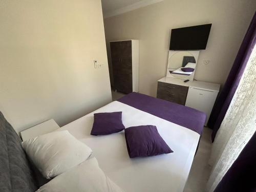 um quarto com uma cama com almofadas roxas e brancas em Paradise Boutique hotel em Pamukkale