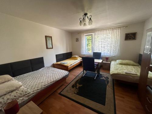 Habitación con 2 camas y mesa con silla. en Pokoje u Danki, en Gdynia
