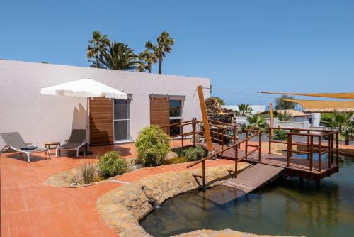 a house with a pool of water next to a building at Finca Roberto by Don Robertos Finca Paraíso in Parque Holandes
