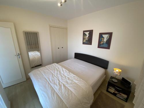 une chambre avec un grand lit blanc dans une pièce dans l'établissement Appartement Quartier Arago, à Les Sables-dʼOlonne