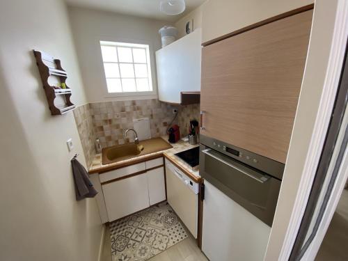 une petite cuisine avec un évier et une cuisinière dans l'établissement Appartement Quartier Arago, à Les Sables-dʼOlonne