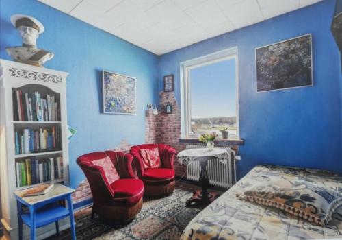 a room with blue walls and red chairs and a window at Casa Mundo Bed & Breakfast in Vejle