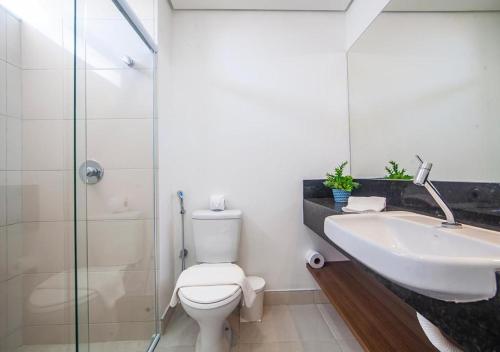 a bathroom with a sink and a toilet and a shower at Loft The Coral Beach Resort in Trairi