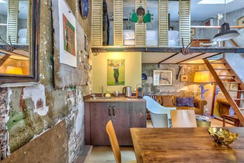 une cuisine en mezzanine avec une table et un évier dans l'établissement Geranimus St Paul Coeur de paris, à Paris