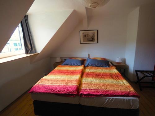1 dormitorio con 1 cama con una manta colorida en Ferienwohnung Am Landesmuseum, en Halle an der Saale