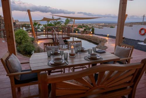 a wooden table and chairs on a patio with a view at Finca Roberto by Don Robertos Finca Paraíso in Parque Holandes