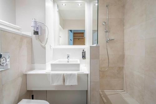 y baño blanco con lavabo y ducha. en ibis Styles Biarritz Plage, en Biarritz